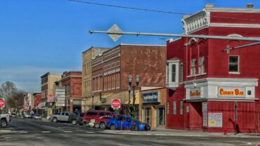 A street scene with cars parked on the side of the road.