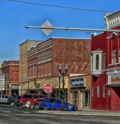 A street scene with cars parked on the side of the road.