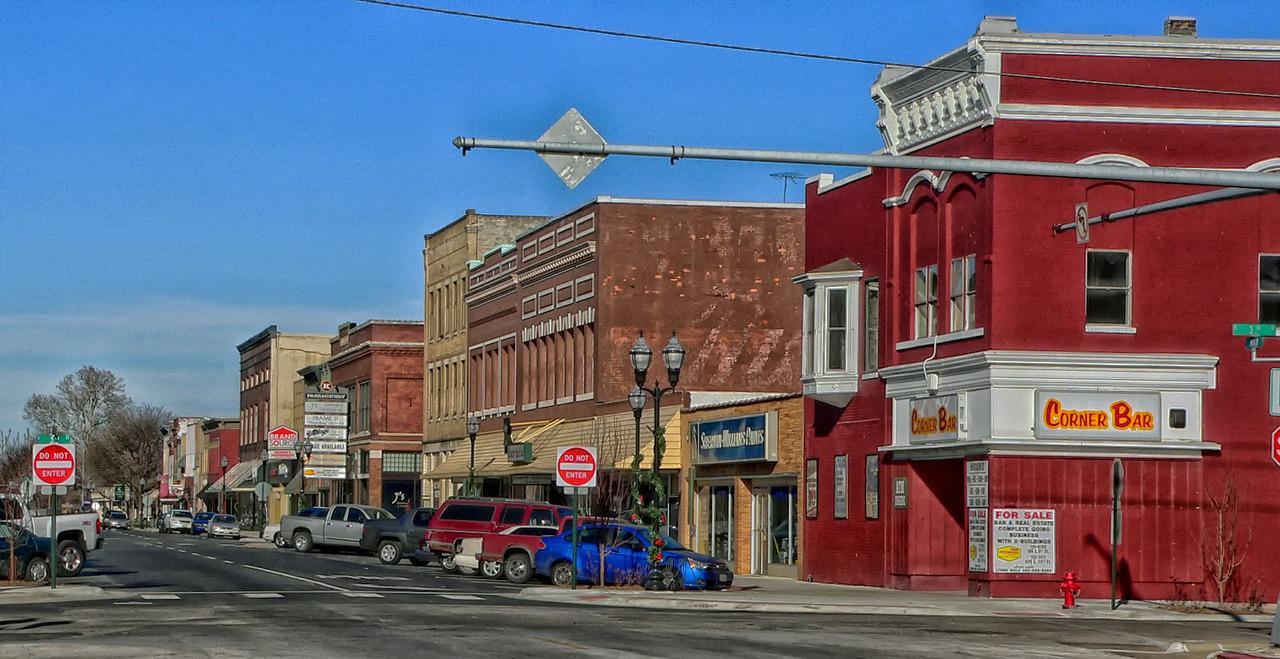 A street scene with cars parked on the side of the road.